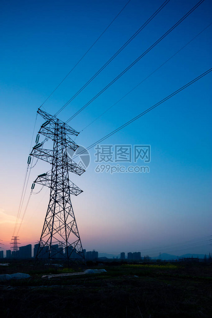 日出时蓝天中的钢制电力塔图片