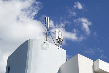 5G智能蜂窝网络天线基站位于建筑物屋顶的电信桅杆上3G4G5G电信背景图片