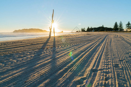 从海滩上修饰的轨道走向日出太阳在沙滩上漂图片