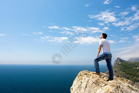 年轻人站在岩石上图片