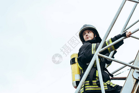 身穿保护制服和头戴盔的女消防员图片