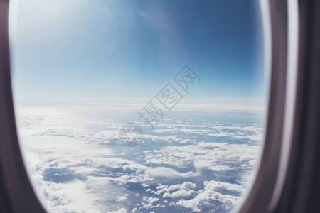 从飞机窗口看蓝色多云的天空图片