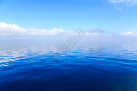 平静的蓝色海水背景是云彩图片