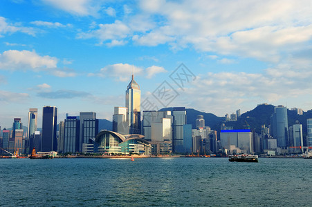 香港维多利亚港的城市建筑白天有蓝色的天空船和云彩图片