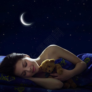 在月亮的背景下晚上睡着的女孩图片