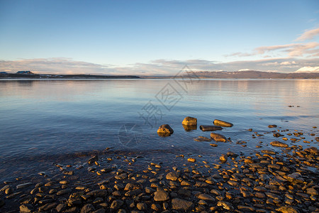 阿根廷巴塔哥尼亚乌斯怀亚的一个美丽平静的湖泊前景中的一些岩石和图片