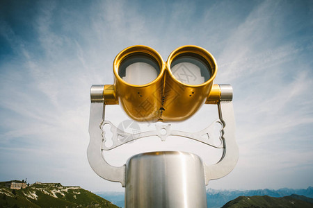 反对蓝天的金旅游双筒望远镜背景图片