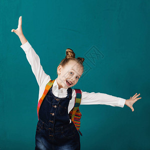 有趣的微笑小女孩背着大背包跳跃背景图片