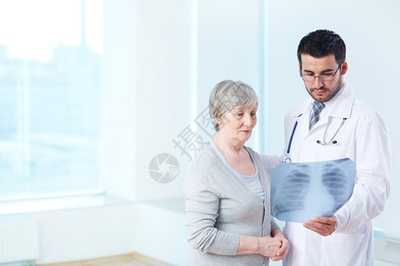高级病人仔细看病中放射科医生在图片