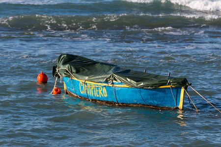 一艘用地布停泊在海湾的小木船图片