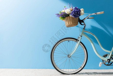 蓝墙前篮子里的自行车前轮图片