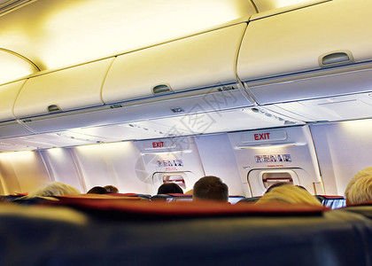 飞机上玩手机坐着乘客的飞机内部安全背景