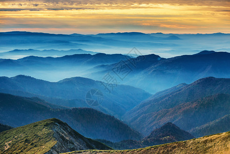 在美丽的日落的蓝色山脉和丘陵图片