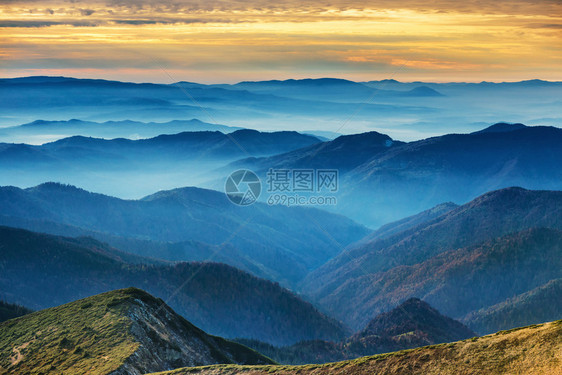 在美丽的日落的蓝色山脉和丘陵图片