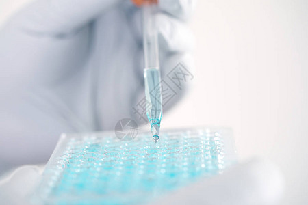 关闭一位在实验室工作的科学家分析微管板中DNA分子的蓝色提取物临床或科学图片