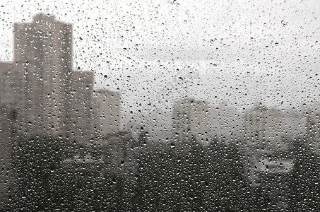 在玻璃背景下有雨滴城市景色会丢弃图片