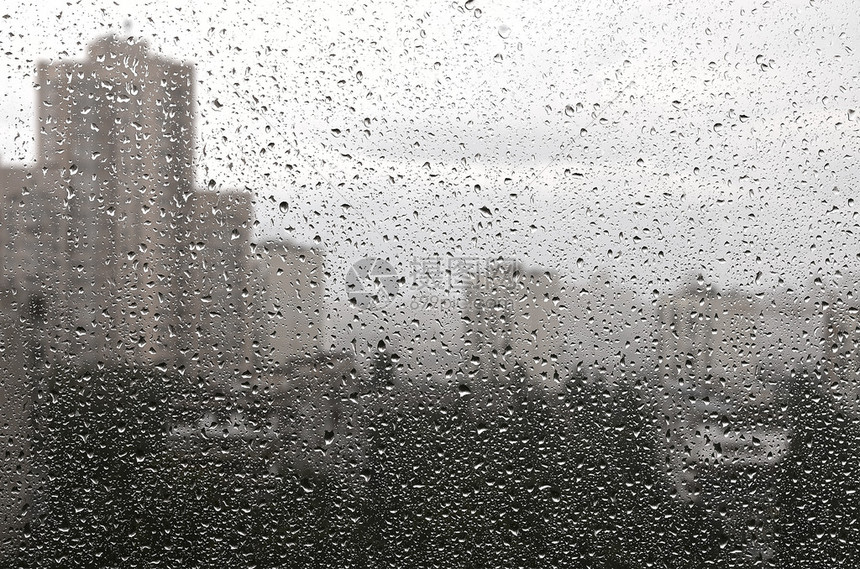 在玻璃背景下有雨滴城市景色会丢弃图片