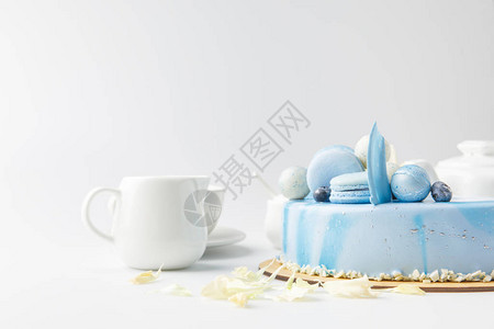 切开板上蓝色蛋糕的一面杯子和锅子图片