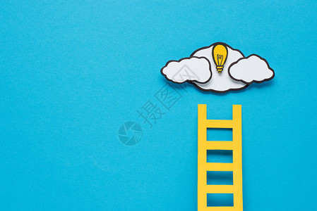 纸板梯灯泡和云有蓝色背景的复制空图片