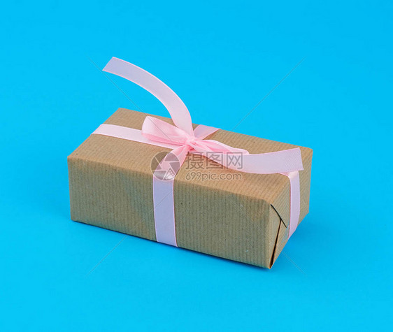 包裹在肉桂牛角纸上并绑有粉色丝带生日礼物和圣瓦伦图片
