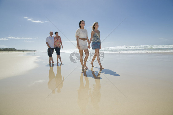 一家人手牵走在沙滩上图片