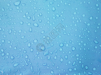 蓝色防水织物纹理背景上的水滴图片