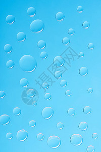 对蓝色背景的透明水滴的仔细观察图片