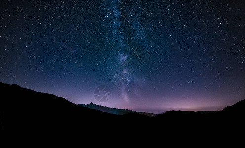 紫色的夜空星横跨山脉的银河系繁星点的夜空背景图片