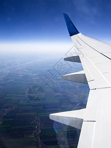 透过飞机的孔洞观察耕地蓝天浅云和部背景图片