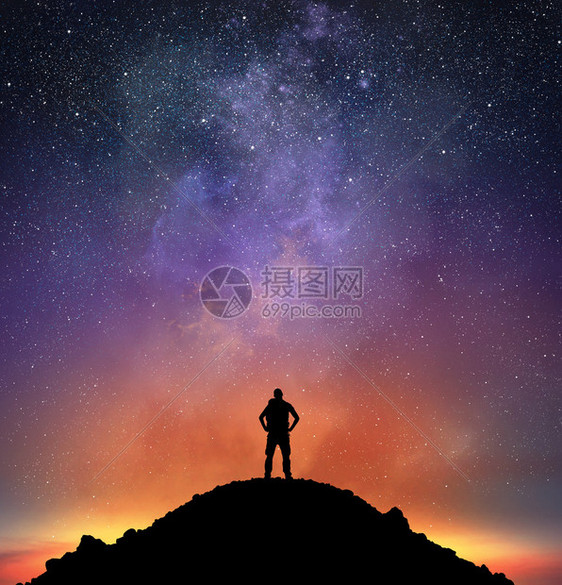 山上的旅行者观察满是星的明亮天空图片