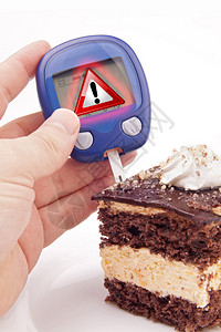 使用警告信号血糖测试在蛋糕一块上图片