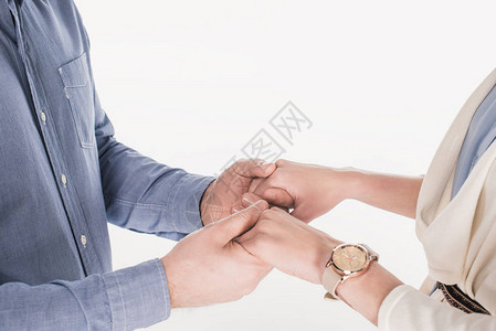 妻子和丈夫用手牵着双手在白背景图片