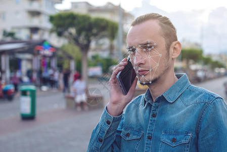 生物特征验证有电话的现代年轻人多边形网格人脸识别新技术的概念是从IT安全和保护图片