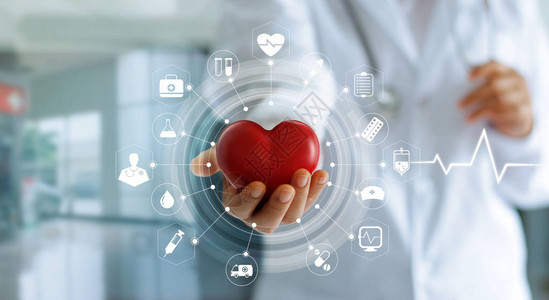 手持红色心形的医学生与现代虚拟屏幕界面医疗技术网络概念的图标图片