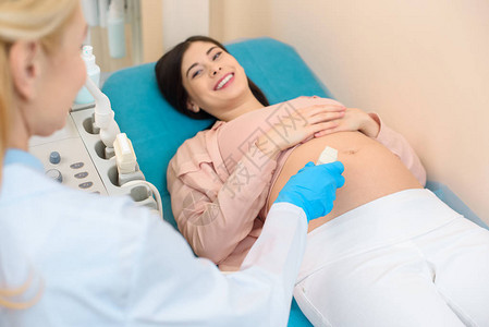 妇产科医生为年轻孕妇进行超声检查图片