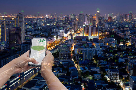 概念技术通信手持机信号与城市建筑夜间双曝光图片