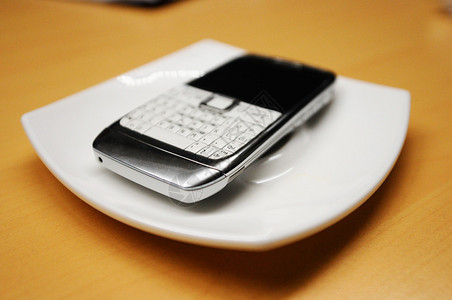 白色盘子上的旧智能手机以左图片