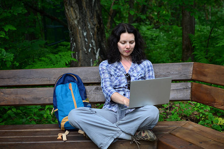 旅行的女人在公园里使用笔记本电脑自由职业者在自然旅行图片