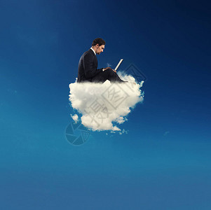 与笔记本电脑相连的商人在天上的云层上社交网络和互联图片