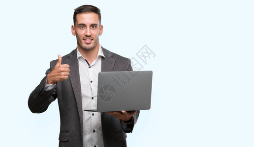 英俊的年轻人用电脑笔记本电脑开心地笑着做好手势图片