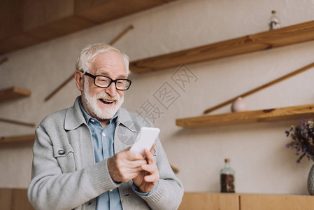 快乐的老人使用智能手机和图片