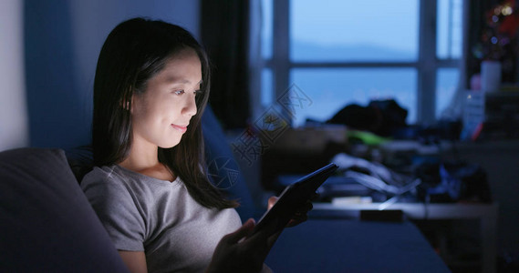 韩国使用平板电脑和晚上在家感到眼痛的年轻女子背景