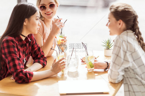 女孩们一起喝鸡尾酒坐在咖啡厅的图片