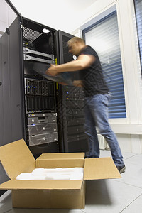 快速工作的IT工程师技术人员在数据中心的机架中安装服图片