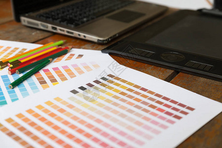 平面设计师艺术家的办公桌在工作数字平板电脑计算机颜色样本调色板目录样本供选择创意编辑器想图片