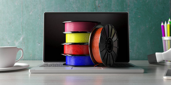 在笔记本电脑办公桌背景上打印3D的彩色塑料丝条图片