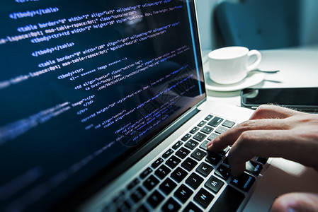 编程工作时间程序员键入新的HTML代码行笔记本电脑和手特写工作时间网页图片