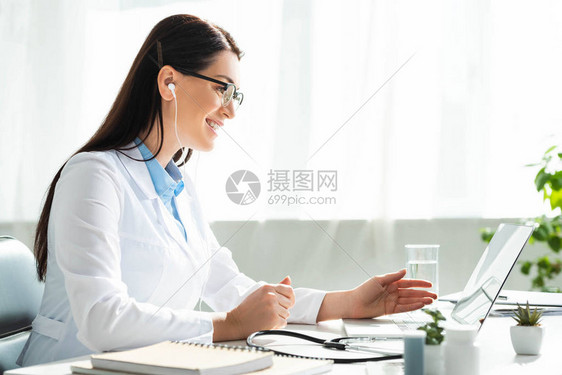 在诊所办公室用笔记本电脑与病人进行在线咨询的耳图片