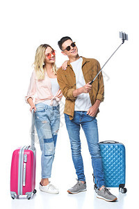 带着手提箱的年轻夫妇用智能手机拍自从单声波图片