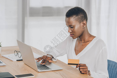 利用笔记本电脑和办公信用卡在网上购物的美丽的非图片